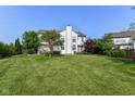 A large backyard with lush lawn, mature trees, and a glimpse of the rear of the house at 18967 Mill Grove Dr, Noblesville, IN 46062