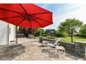 Outdoor patio area with stone pavers, featuring a red umbrella and outdoor furniture at 18967 Mill Grove Dr, Noblesville, IN 46062