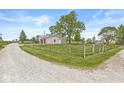 Expansive backyard with a gravel driveway, fencing, and a well-kept lawn at 20530 Victory Chapel Rd, Noblesville, IN 46060