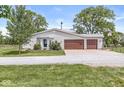 Home featuring a two-car garage, well-manicured lawn, and a circular driveway at 20530 Victory Chapel Rd, Noblesville, IN 46060