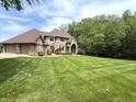 A brick two-story house with an attached garage sits on a large, well-manicured lawn surrounded by mature trees at 2925 N Country Club Rd, Martinsville, IN 46151