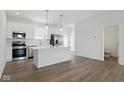 Open kitchen with stainless steel appliances, a center island, and view of the living area at 3931 Wren Dr, Brownsburg, IN 46112