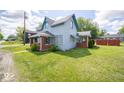 Charming two-story home with a covered porch, red brick, and a well-maintained lawn on a bright day at 5 E Jefferson St, Maxwell, IN 46154