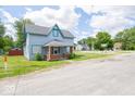 Charming two-story home with covered porch, blue siding, and well-kept lawn on a bright day at 5 E Jefferson St, Maxwell, IN 46154