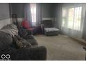 Comfortable living room featuring a large window that allows natural light in to illuminate the carpet at 513 Andover Rd, Anderson, IN 46013