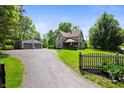 Quaint home with a detached garage, long driveway, and a charming picket fence at 5253 W 8Th Street Rd, Anderson, IN 46011