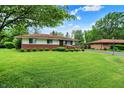 Well-kept lawn and mature trees complement this charming one-story home's curb appeal at 5349 Culver St, Indianapolis, IN 46226