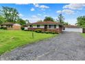 Ranch-style home with a lush green lawn and long driveway leading to an attached garage at 5349 Culver St, Indianapolis, IN 46226