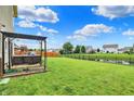 Expansive backyard featuring lush green grass, an iron fence, and a relaxing swing at 5598 W Woodstock Trl, McCordsville, IN 46055