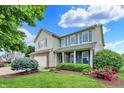 Attractive two-story home with blue shutters and a meticulously landscaped yard at 5598 W Woodstock Trl, McCordsville, IN 46055