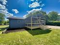 Rear exterior showcasing the house and deck, surrounded by a freshly mowed lawn at 5861 N 330 W, Columbus, IN 47201