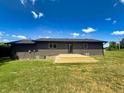Backyard view features a wooden deck, siding, and manicured green lawn at 5861 N 330 W, Columbus, IN 47201