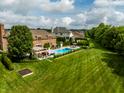 Expansive backyard featuring a swimming pool, lush lawn, outdoor dining area, and mature trees at 6639 E Deerfield Dr, Zionsville, IN 46077