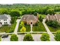 Beautiful aerial view of a two-story brick home with a well-manicured lawn and lush green surroundings at 6639 E Deerfield Dr, Zionsville, IN 46077