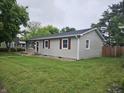 Well-maintained single-story home with gray siding, red shutters, and a spacious front lawn at 720 Henry St, Lebanon, IN 46052
