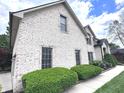 Charming white brick home featuring manicured landscaping, a well-maintained lawn, and a welcoming facade at 7823 Ashtree Dr, Indianapolis, IN 46259