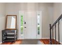 Bright foyer with hardwood floors, white door with sidelights, and a stylish accent table at 8376 Glen Highlands Dr, Indianapolis, IN 46236