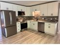 Bright kitchen featuring stainless steel appliances, white cabinets, and stylish backsplash at 10328 Central Ave, Carmel, IN 46280
