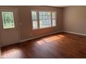 Inviting living room with gleaming hardwood floors, a large window, and a door leading outside at 10328 Central Ave, Carmel, IN 46280