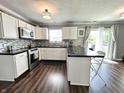 Bright kitchen with white cabinets, stainless steel appliances, black countertops and a sliding glass door to the outside at 10847 Woodlook Ln, Indianapolis, IN 46239