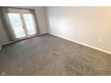 Bright bedroom with gray carpet, white trim, and french doors to a private balcony at 12860 University Cres # 1B, Carmel, IN 46032