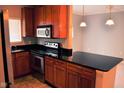 Updated kitchen boasts stainless steel appliances, dark countertops and ample wood cabinets for storage at 12860 University Cres # 1B, Carmel, IN 46032