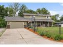 Inviting two-story home featuring a spacious driveway, a basketball hoop, and a charming covered porch at 12920 N Oakhaven Dr, Camby, IN 46113