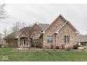 Classic brick home with a lovely garden, showcasing timeless architectural details at 1344 S Fox Paw Dr, New Palestine, IN 46163