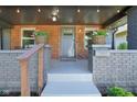 Inviting front porch with brick accents, decorative plants, and covered lighting at 1421 S New Jersey St, Indianapolis, IN 46225