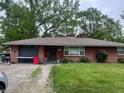 Charming brick ranch-style home with mature trees and a well-maintained front lawn at 2330 Ridgewood Dr, Anderson, IN 46012