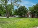 Single story brick home with a green lawn and mature shade trees at 3602 N Colorado Ave, Indianapolis, IN 46218
