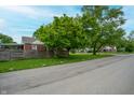 Street view featuring a brick home with green trees and blue skies offering a peaceful setting at 3602 N Colorado Ave, Indianapolis, IN 46218