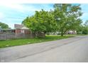 Street view of a residential area with a brick home and mature trees at 3602 N Colorado Ave, Indianapolis, IN 46218