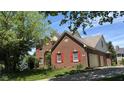 Charming brick home featuring a well-maintained lawn, red shutters and an attached garage at 404 Joseph Way, Carmel, IN 46032