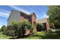 Charming brick home featuring a well-maintained lawn, red shutters and a covered entry at 404 Joseph Way, Carmel, IN 46032