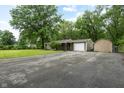 Wide driveway leading to a single-story home with detached garage and large lawn at 5422 Orange St, Indianapolis, IN 46203
