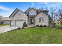 An attractive two-story brick home boasts a three-car garage and a lush green lawn at 545 Walnut Woods Dr, Greenwood, IN 46142