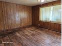 Spacious bedroom featuring wood paneling and flooring, bathed in soft, natural light at 5558 Bertha St, Indianapolis, IN 46241