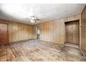 Large living room showcasing hardwood floors, paneled walls, and a ceiling fan fixture at 5558 Bertha St, Indianapolis, IN 46241