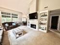 Bright living room featuring a fireplace, built-in shelving, high ceilings, and an open layout at 6366 Stratford N Dr, Fishers, IN 46038