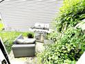 Backyard patio with grill, seating, and lush green plants, perfect for outdoor relaxation at 6640 Sundown S Dr, Indianapolis, IN 46254