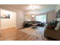 Comfortable living room with large windows, a sectional sofa, and wood-look flooring at 6799 Lakeshore Dr, Avon, IN 46123