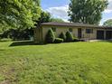Brick home featuring a spacious lawn and well-maintained landscaping and attached two-car garage at 7015 Westlake Rd, Indianapolis, IN 46214