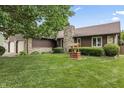 Charming home featuring a stone chimney, well-manicured lawn, and attractive landscaping at 7426 N Carroll Rd, Indianapolis, IN 46236