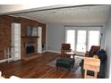 Spacious living room featuring a brick fireplace, wood floors, and ample natural light at 7443 Country Brook Dr, Indianapolis, IN 46260