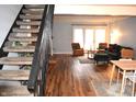View of the living room with wood floors and a staircase with dark railings at 7443 Country Brook Dr, Indianapolis, IN 46260