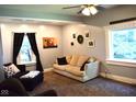 Cozy living room featuring neutral walls, plush carpet, comfortable seating, and natural light from the windows at 8373 W State Road 47, Thorntown, IN 46071