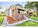 Beautifully landscaped front yard with brick accents highlighting the covered front porch at 920 E Tabor St, Indianapolis, IN 46203