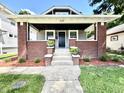Charming home featuring an inviting covered front porch, brick accents, and meticulous landscaping at 920 E Tabor St, Indianapolis, IN 46203