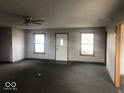 Spacious living room with neutral paint, a ceiling fan, and natural light from two windows at 1045 Springway Dr, Shelbyville, IN 46176